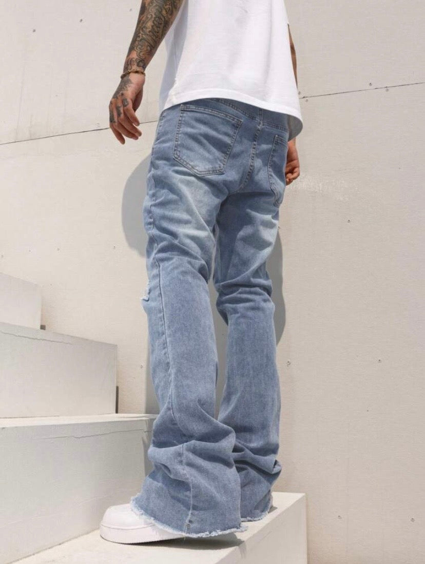 Jean bootcut pour homme avec effet usé, poches et ourlet effiloché, coupe évasée style casual streetwear.