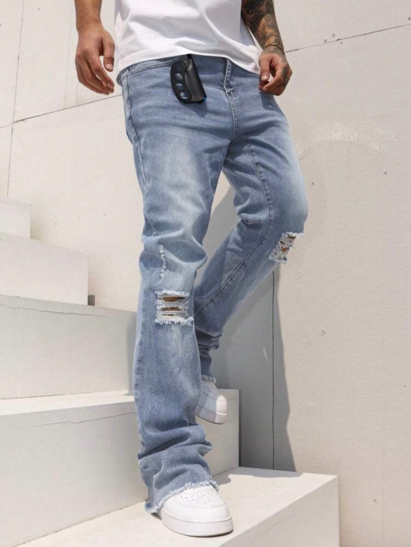 Jean bootcut pour homme avec effet usé, poches et ourlet effiloché, coupe évasée style casual streetwear.