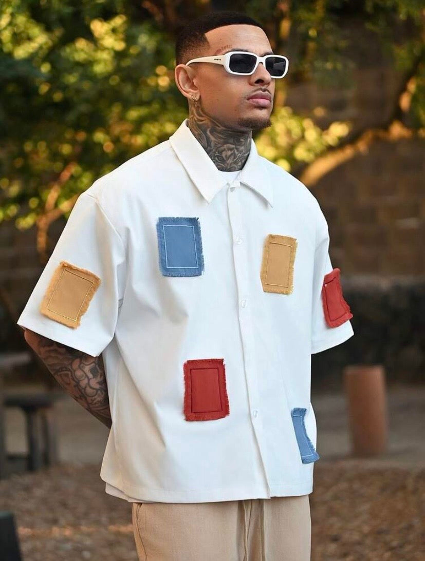 Chemise décontractée pour homme à coupe ample avec broderies et détails contrastés, idéale pour un style estival moderne.
