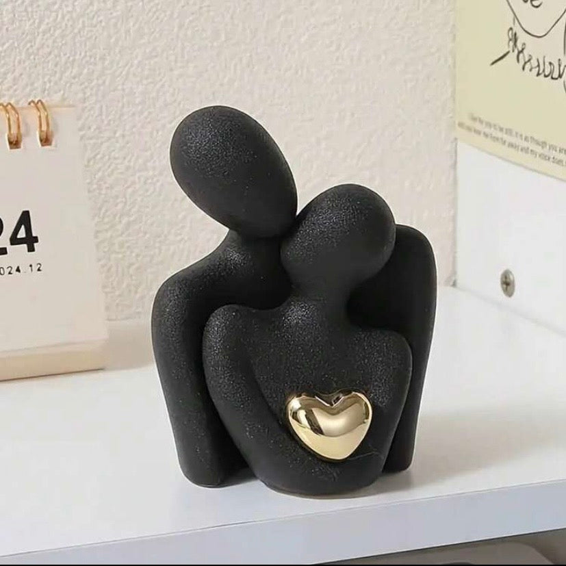 Statue moderne représentant une étreinte amoureuse avec cœur doré, décoration élégante pour salon, chambre ou bureau.