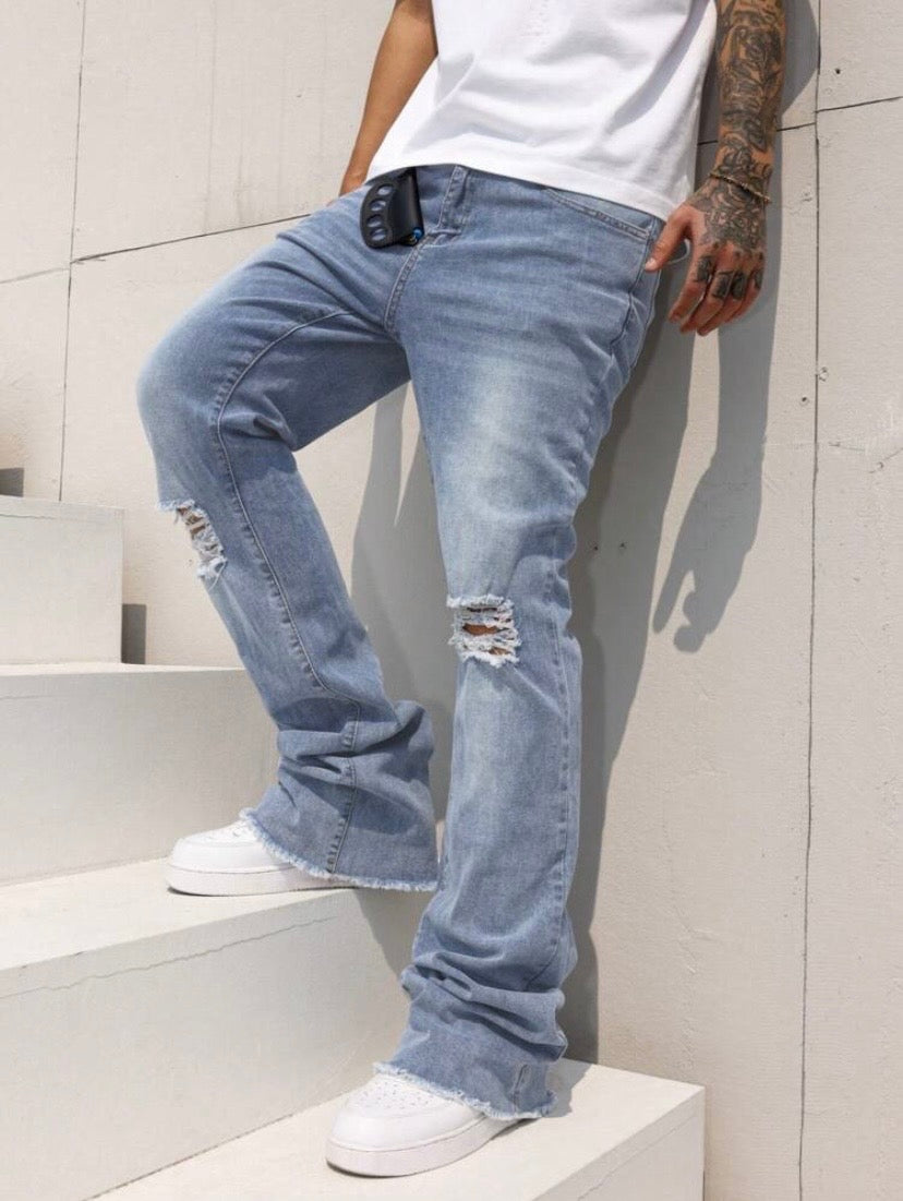 Jean bootcut pour homme avec effet usé, poches et ourlet effiloché, coupe évasée style casual streetwear.
