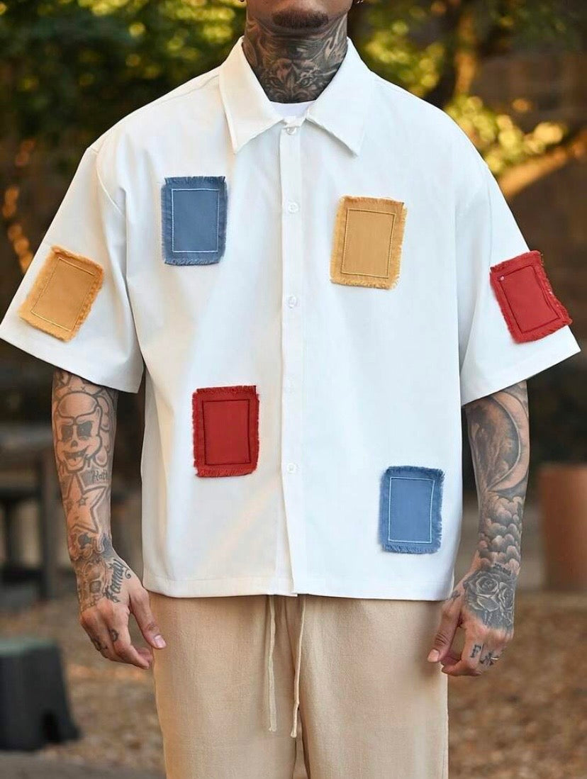Chemise décontractée pour homme à coupe ample avec broderies et détails contrastés, idéale pour un style estival moderne.