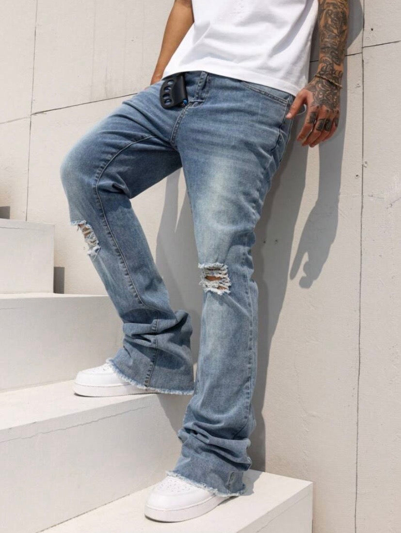 Jean bootcut pour homme avec effet usé, poches et ourlet effiloché, coupe évasée style casual streetwear.
