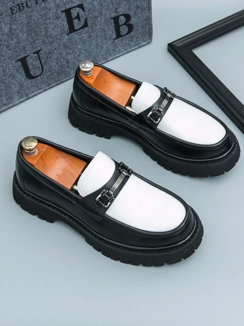 Mocassins habillés pour homme en noir et blanc avec finition brillante et pampilles décoratives, parfaits pour un style professionnel raffiné.