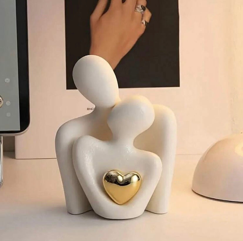 Statue moderne représentant une étreinte amoureuse avec cœur doré, décoration élégante pour salon, chambre ou bureau.