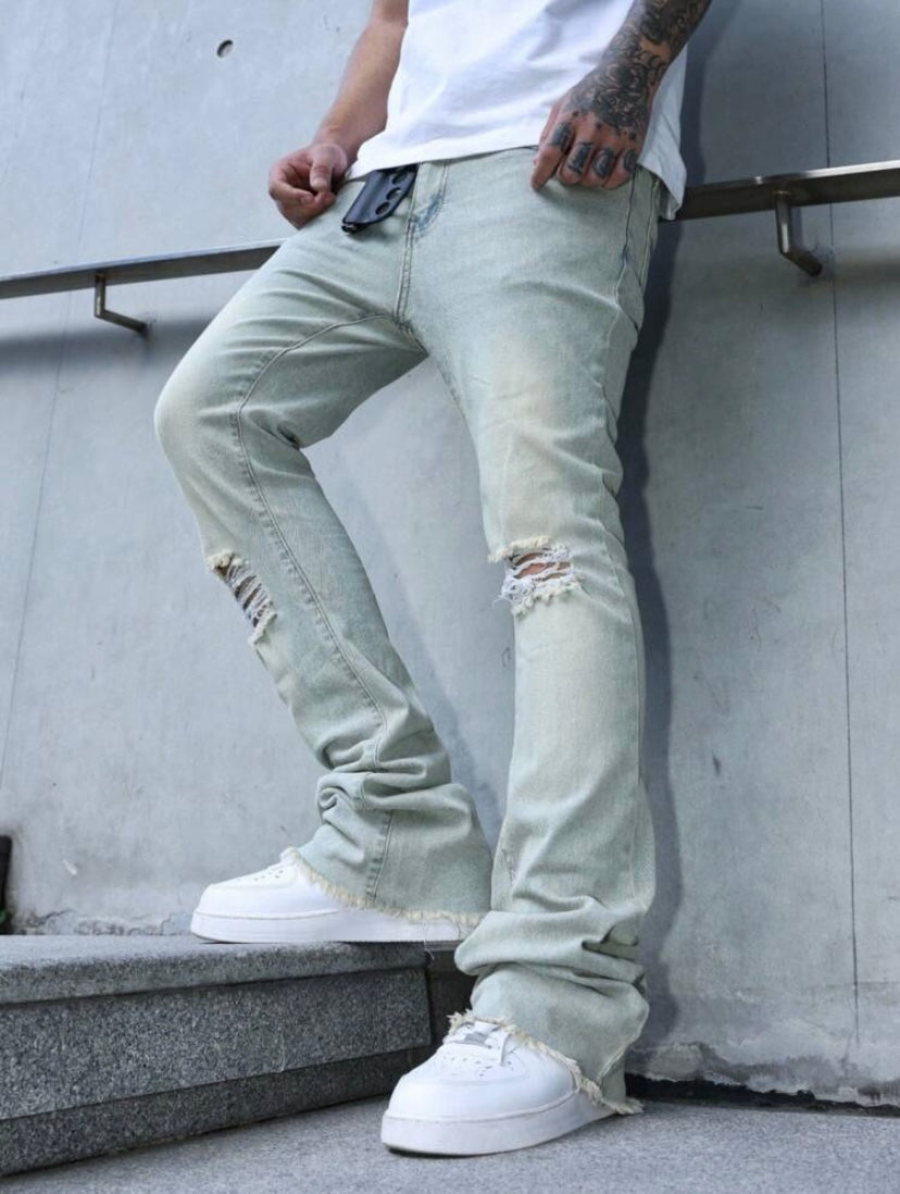 Jean bootcut pour homme avec effet usé, poches et ourlet effiloché, coupe évasée style casual streetwear.