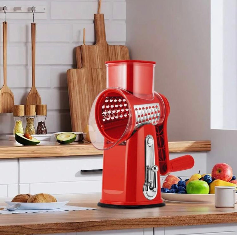 Râpe rotative manuelle avec poignée et lames interchangeables, base ventouse et rangement intégré, idéale pour fromage, légumes et fruits secs.