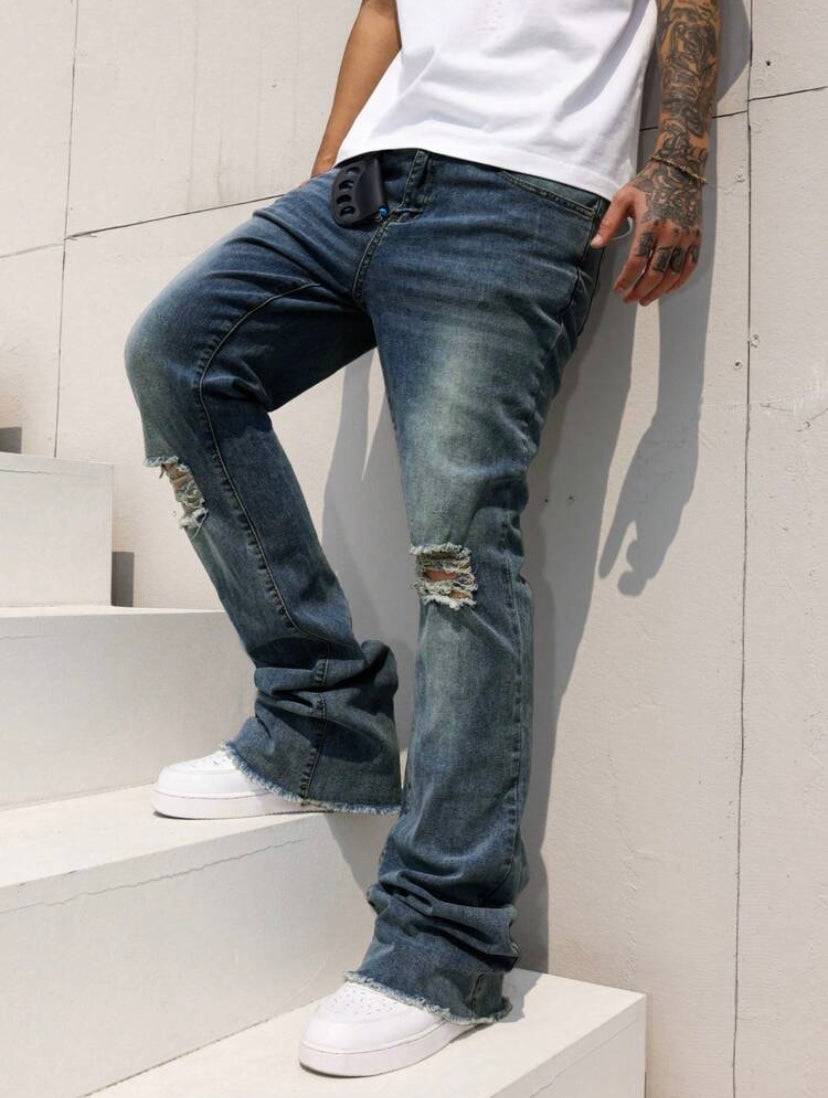 Jean bootcut pour homme avec effet usé, poches et ourlet effiloché, coupe évasée style casual streetwear.