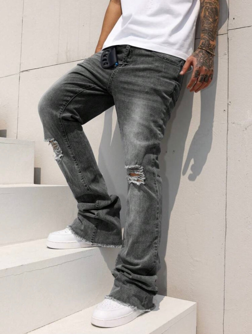 Jean bootcut pour homme avec effet usé, poches et ourlet effiloché, coupe évasée style casual streetwear.
